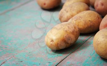 Raw potatoes on grunge wooden background
