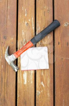 Vertical photo of work hammer and sand paper on natural faded cedar wood deck