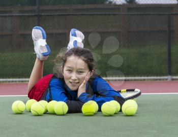 Young girl having fun on outdoor tennis court
