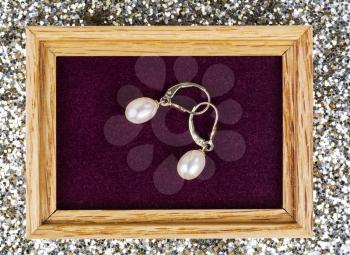 Golden Pearl Earrings in Jewelry Box with Glitter in background