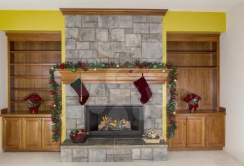 Large Natural Gas fireplace decorated for the holidays with accent yellow wall in background