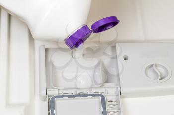 Horizontal photo of detergent being poured into dishwasher soap dispenser 