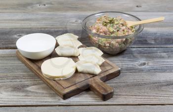 Horizontal photo of homemade traditional Chinese Dumplings being made from raw ingredients 
