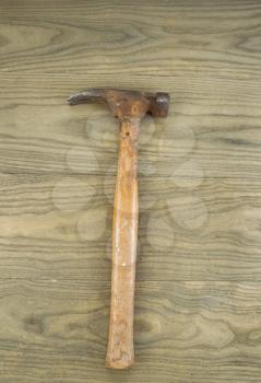 Vertical photo of an old claw hammer on aged wood