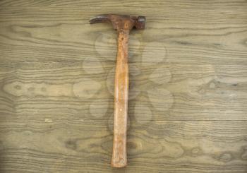 Horizontal photo of an old claw hammer on aged wood