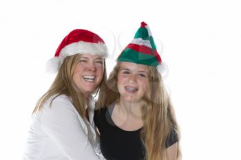 Front view, shoulders up, of mother and her teen daughter wearing Christmas hats isolated on a white background 