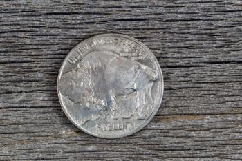 Closeup image of American Buffalo Nickel, reverse side, on rustic wood 