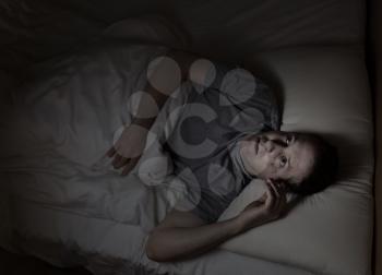 Top view image of mature man restless in bed from insomnia