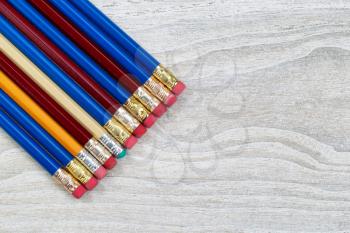 Pencil erasers lined up on rustic white wood 