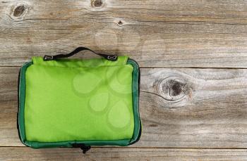Top view shot of a weather proof nylon medical kit bag for outdoor travel on rustic wooden boards.