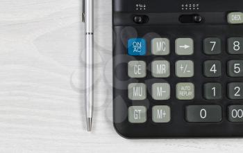 Close up of a financial calculator and pen on desktop. 