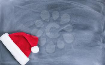 Santa cap on erased chalkboard for Christmas wish list concept.