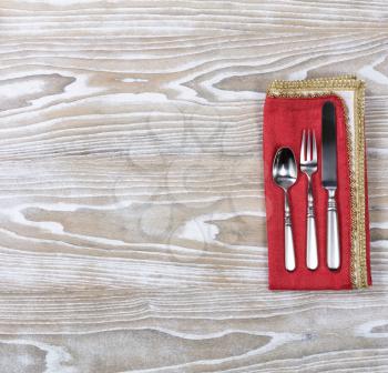 Overhead view of a festive cloth napkin with dinner set silverware. 