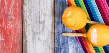 Cinco de Mayo holiday concept in USA with Mexican maracas on rustic wood painted traditional colors of United States.