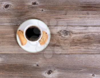 Overhead view of dark coffee and cookies on rustic wooden table 