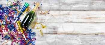 New Year eve party decorations and champagne with drinking glasses on rustic white wooden background 