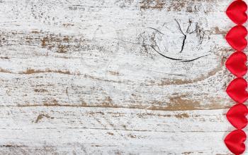 Red hearts on rustic white wood in flat lay view