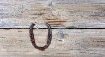 rusty horseshoe on rustic wooden boards in overhead view 