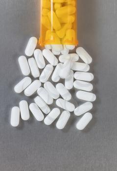 Oxycodone opioid tablets and bottle in overhead view