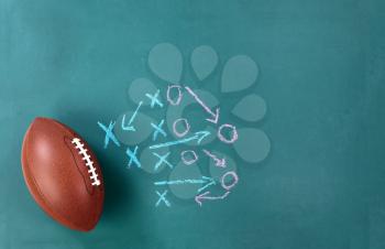 American football with game plan on cleaned chalkboard 