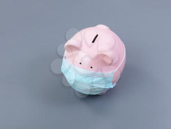 Piggy bank with surgical mask on face