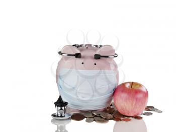 Piggy bank with medical mask, apple, coins and stethoscope. Financial crisis concept. Isolated on white with reflection. 