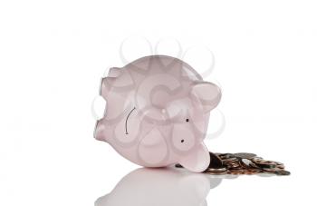 Tipped over piggy bank and coins for financial crisis concept. Isolated on white with reflection. 