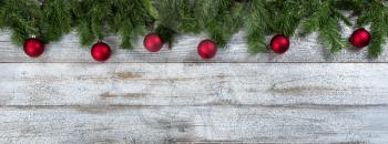 Border of Evergreen branches with red ball ornaments for Christmas or New Year holiday background 