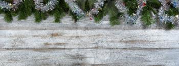 Border of Evergreen branches with tinsel decoration for Christmas or New Year holiday background 
