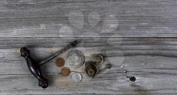 Vintage collection of coins, wine corkscrew and antique lock on weathered wooden planks  