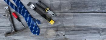 Blue striped necktie and hand tools on aged wooden planks for Happy Fathers Day concept