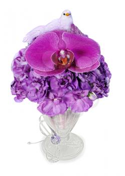 colorful arrangement of orchids, hydrangeas and blue birds held vertically in a glass vase, isolated on white background