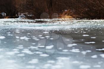 Frozen river with ice and sun reflection. Selective focus.