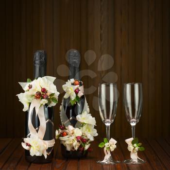 Champagne Bottles with Glass and Wedding Decoration of Flower Arrangements on Wooden Background.