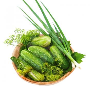 Cucumbers and vegetables and dill leaves still life in wooden bowl isolated on white background. Closeup
