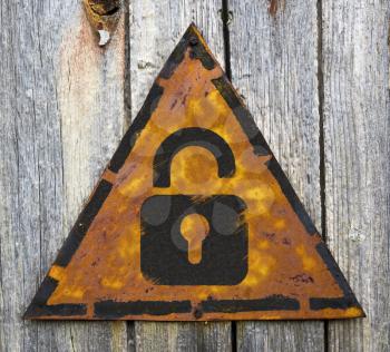 Royalty Free Photo of a Padlock on a Rusty Sign Against a Wooden Wall