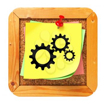 Cogwheel Gear Icon on Yellow Sticker on Cork Message Board.