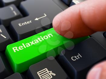 Relaxation - Written on Green Keyboard Key. Male Hand Presses Button on Black PC Keyboard. Closeup View. Blurred Background.