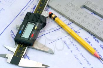 Royalty Free Photo of a Digital Calliper and Blueprints