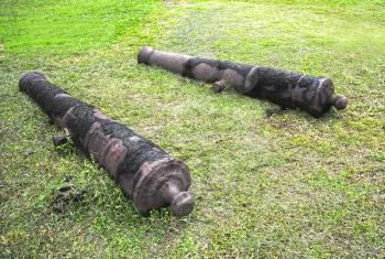 Two old Spanish cannons laying on the grass at the Saint Geronimo's castle grounds in Portobelo Panama