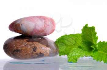 Zen stones with mint leaves on white