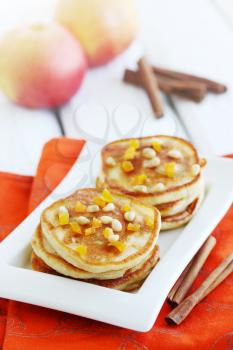 Fried pancakes with apples, dried apricots and pine nuts