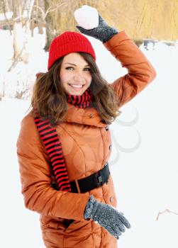 woman in a red cap throwing snowball