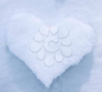 White icy heart on the background of snow
