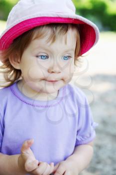 Little girl in a hat with a sly look on his face