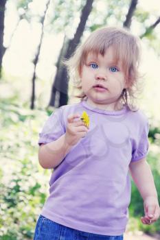 Little girl with dandelion in the spring park