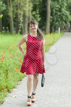 Young beautiful girl in a dress for a walk in the park.