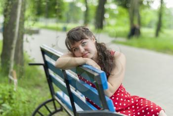 Portrait of a beautiful girl on a park bench.