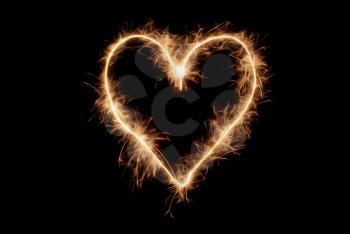 Heart drawn sparklers on black background.