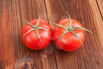 Ripe tomatoes closeup on wooden background.
